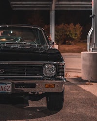 a black chevrolet chevelle parked in front of a gas station