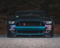 the front end of a blue ford mustang